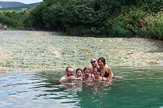tourists bathe in a hot river