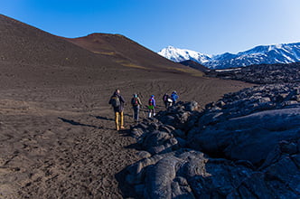 a group of tourists walking past solidified lava